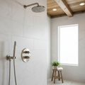 Thermostatic shower valve and trim kit in brushed nickel in a luxury marble walk-in shower